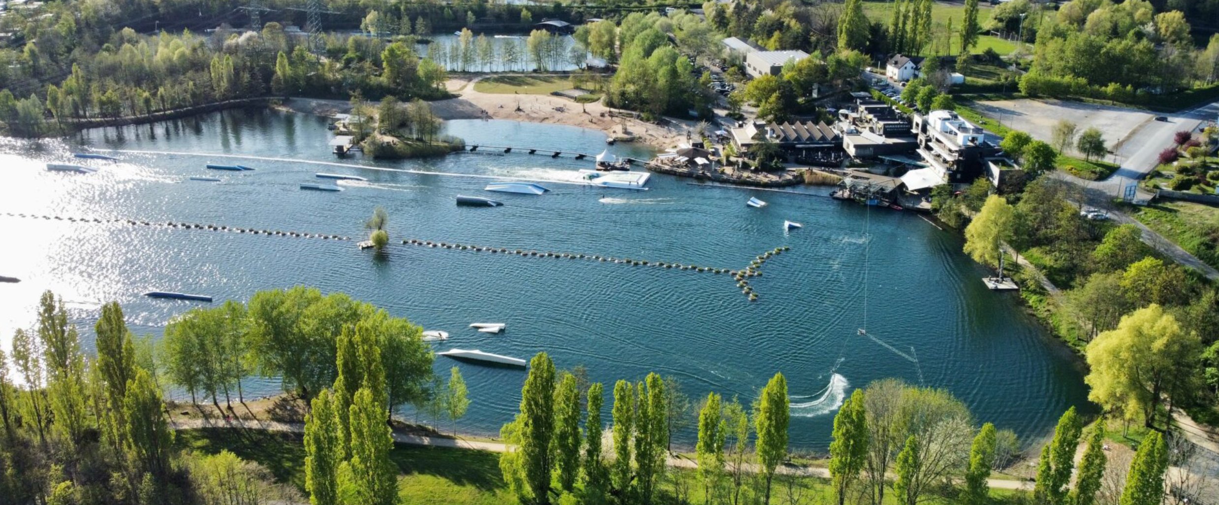 Luftaufnahme des Freizeitsees mit Wasserski-Anlage bei Langenfeld